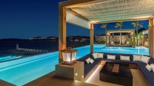 foto aussenbereich mit überdachten sitz ecken in einem grossen pool mit meeres blick auf das dunkel blaue meer im luxuriösen hochklassigen exklusiven designer hotel santa marina auf mykonos in griechenland europa